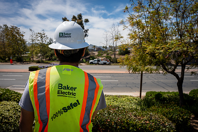 Baker Electric worker in safety gear overlooking a roadway near the project site.