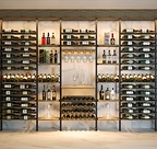A floor-to-ceiling Somm Series installation combining wine and spirits storage, stemware and a tasting station — built on Kessick's newly patented concave pole system.