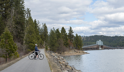 A cyclist takes in the view from the Trail of the Coeur d'Alenes in northern Idaho. The nonprofit, Friends of the Coeur d'Alene Trails, is among the 2026 recipients of Rails to Trails Conservancy's trail grants program, which distributed more than $435,000 in funding to organizations advancing trail network development nationwide this year. Since 2008, RTC has provided over $4.5 million in grants to create, connect and maintain America's trails. Photo by Lisa James, courtesy of RTC.