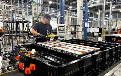 A GM team member installs battery modules with cells made with recycled battery materials into a new battery pack at Factory ZERO.