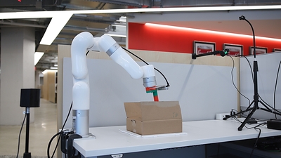 BoxBot, a Viam research robot that cuts the tape on sealed cardboard boxes and opens the flaps. Shown from overhead, the side, and up close at Viam’s robotics lab in New York City.
