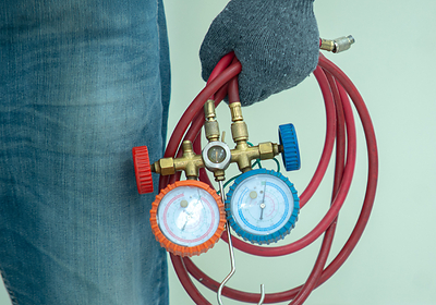 Close-up image of HVAC technician carrying tools