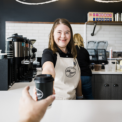 Bitty & Beau's Coffee employee serves guest.