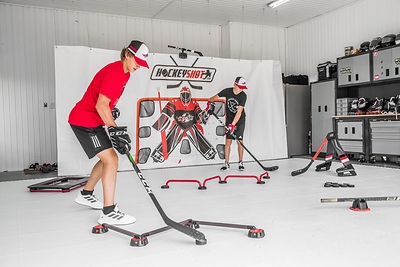 Young hockey players train their skills year-round with HockeyShot's off-ice training system, combining All-Star dryland tiles, shooting, stickhandling, and agility equipment in a dedicated training space.