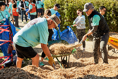 Foresters Financial International Fraternal President Richard Hennick (left) and President and CEO Matt Berman (right) load wood chips for the playground’s safety surfacing at Maple Glen Housing Co-operative in Oshawa.