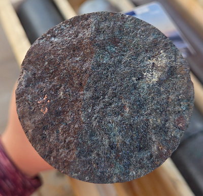 Photo 6: DH26CC-004, 358.0 m, broken core face showing a fleck of native copper within tuff host rock. Selected specimen; visual observation only, not representative of grade; assays pending.