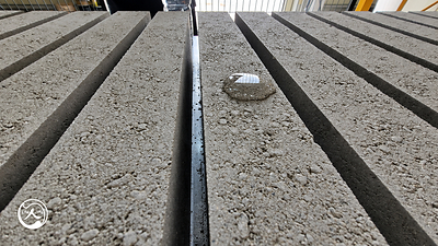 Close-up of concrete strips on Samjung MetaBoards, with a bead of water visible on one strip.