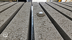 Close-up of concrete strips on Samjung MetaBoards, with a bead of water visible on one strip.