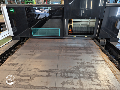 A steel sheet with outlined board profiles lies on the cutting bed of an industrial laser cutting machine. A steel sheet with outlined board profiles lies on the cutting bed of an industrial laser cutting machine.