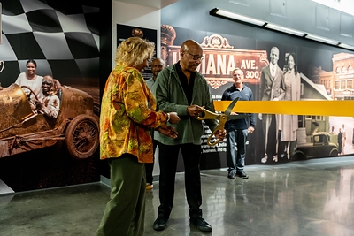 Guest Curator and retired General Motors chief of design Ed Welburn cuts the ribbon alongside Angi Rogers, the great niece of Charlie Wiggins. Guest Curator and retired General Motors chief of design Ed Welburn cuts the ribbon alongside Angi Rogers, the great niece of Charlie Wiggins.