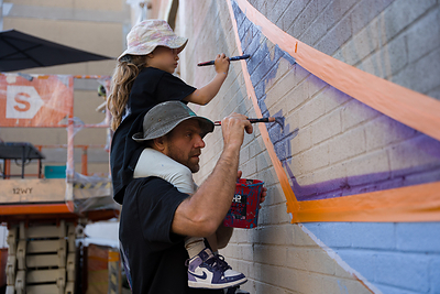 Fluke and his six-year-old daughter work together on the World Animal Protection inspired mural. Credit: The Dream Catcher Production.