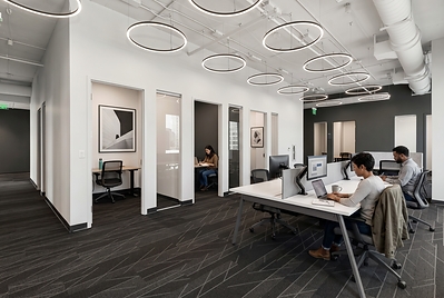 Open workspace and private offices at e|spaces Orlando, with professionals working at shared desks.