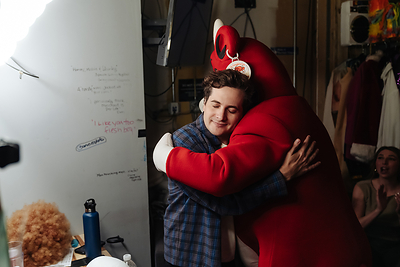Saturday Night Live cast member Jeremy Culhane shares a hug with The Laughing Cow® backstage at Chicago's The Second City ahead of a special comedy performance to help bring back her iconic laugh.