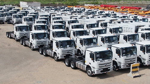 Rows of white XCMG on-highway trucks are lined up at a facility in preparation for delivery to Zambia as part of a major order deal. This image opens in the lightbox