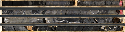 Photo 2: An interval of laminated to semi-massive sulphide mineralization in TS26-005 consisting of laminated to semi-massive sphalerite, galena, barite and black mudstone from 176.3 to 180.8 m