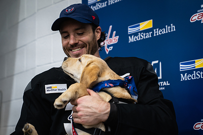 Matt Roy, pictured with Bravo, a service dog-in-training, recorded the 200th blocked shot of the season for the Washington Capitals — officially driving CACI's donation total to $50,000.